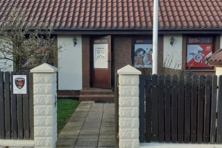 Dostawczy samochód z częściami przy sklepie Auto-Lieder w Pucku z tablicą godzin otwarcia