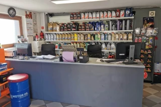 Stanowisko obsługi klienta z półkami z częściami i akcesoriami motoryzacyjnymi w sklepie Auto-Lieder w Luzinie