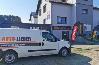 Widok zewnętrzny sklepu motoryzacyjnego Auto-Lieder w Luzinie z autem do transportu części samochodowych